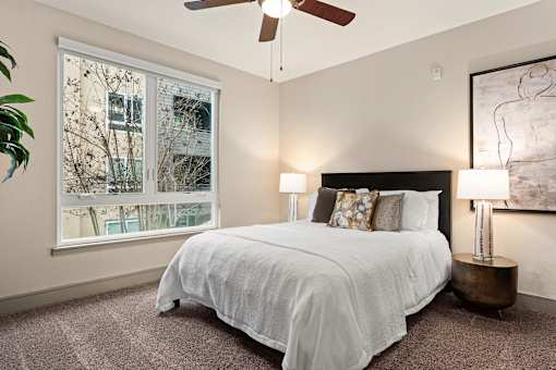 A bedroom with a large bed and a ceiling fan.