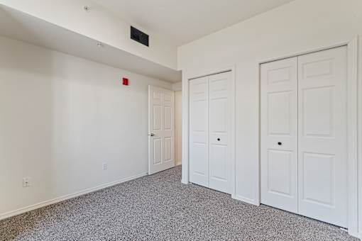 A room with white walls and a grey carpet.