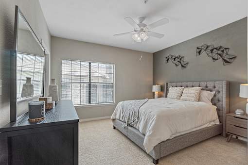 A bedroom with a large bed and a ceiling fan.
