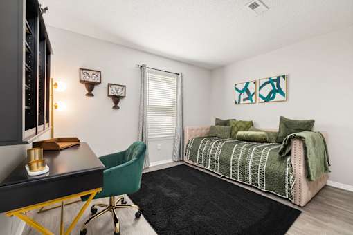 A room with a bed, a desk, and a chair.