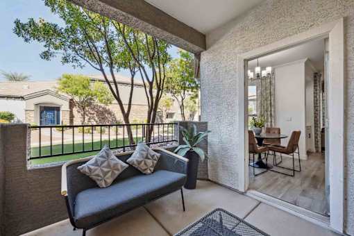 A patio with a couch and a table with chairs is shown.