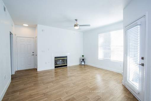 A room with a fireplace and a plant on a small table.