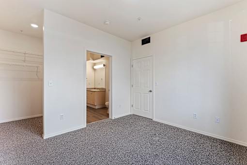 A large empty room with a doorway leading to another room.