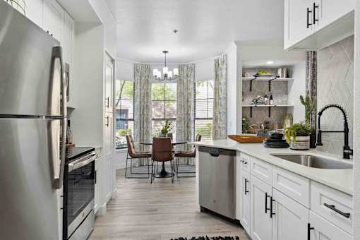 A modern kitchen with a dining table and chairs.