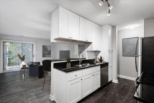a kitchen with white cabinets and a black counter top