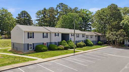 A row of houses with a parking lot in front.