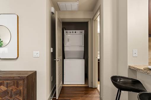 A small kitchen with a white fridge and a black chair.