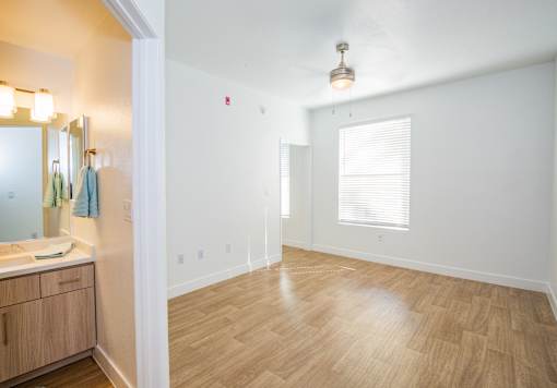 A bathroom with wooden floors and a white wall.