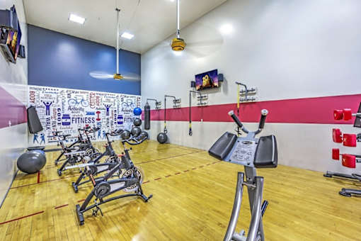 A gym with a variety of equipment including weights and exercise machines.