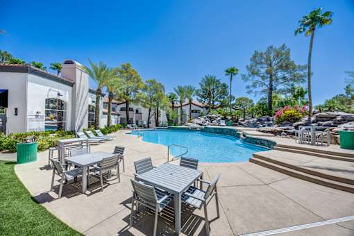 A pool area with a table and chairs.