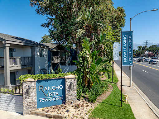 A sign for Rancho Vista Townhomes is displayed in front of a building.