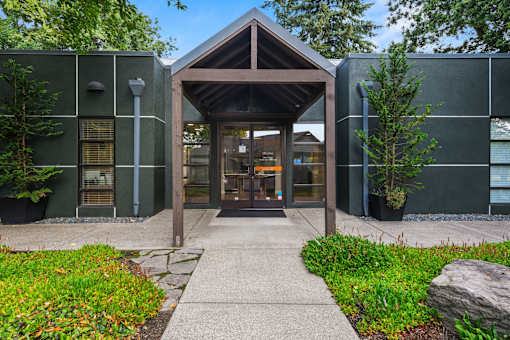 A building with a wooden entrance and a stone pathway leading to it.