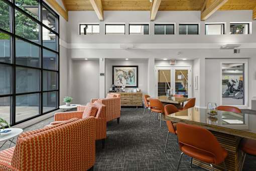 A room with orange chairs and a wooden ceiling.