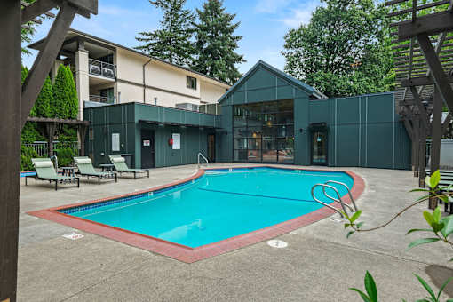 A small pool in a backyard with a wooden pergola.