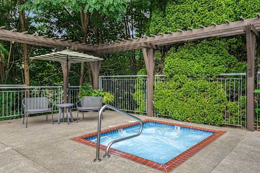 A small pool surrounded by a fence and a pergola.