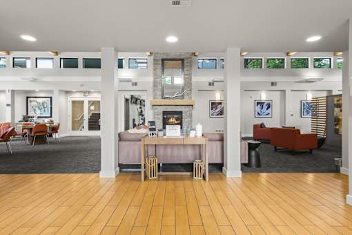 A spacious room with wooden floors and furniture.