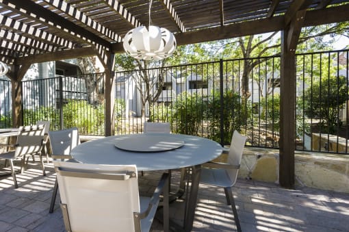 a patio with a table and chairs under a pergola