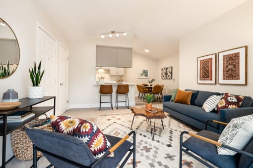 Contemporary living room with cozy seating and geometric rug at Canyon Creek Apartments, Oregon