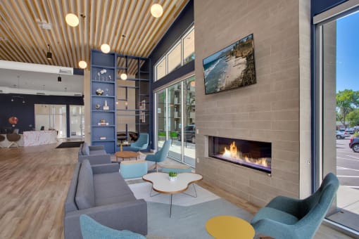 a living room with a fireplace and blue chairs and couches