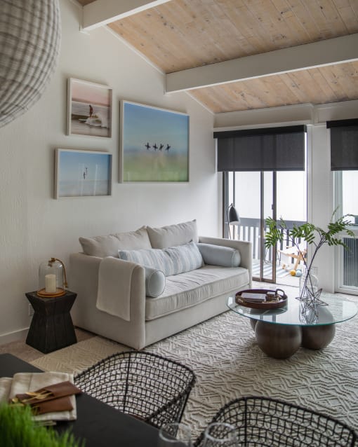 a living room with a couch and a table and a balcony