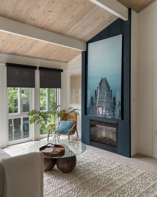 a living room with a fireplace and a large picture of a staircase