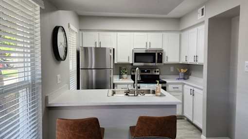 A modern kitchen with white cabinets and a large island.
