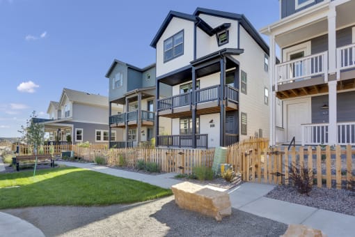 an exterior view of an apartment building with a sidewalk and grass