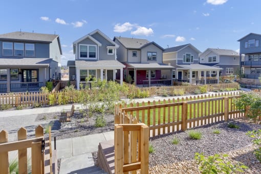 a row of houses with a yard and a wooden fence