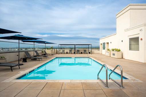 A swimming pool with a blue tiled edge and a metal ladder.