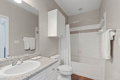 A white bathroom with a sink, toilet, and bathtub.