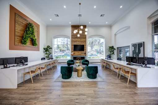 A modern office space with a long white reception desk and green chairs.