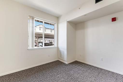 A room with a window and a fire extinguisher on the wall.