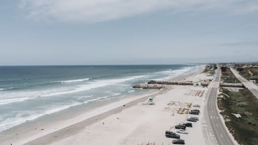 a view of the beach and the road next to the ocean