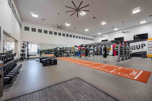 A gym with a variety of equipment and a large mirror on the wall.