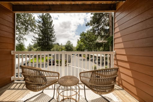 Private balcony with wicker chairs and scenic outlook at Canyon Creek Apartments, Wilsonville, Oregon
