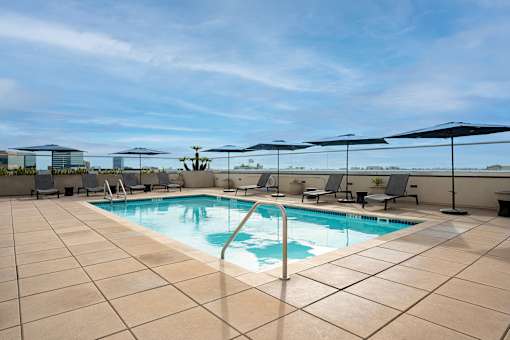 A swimming pool with a tiled floor and a metal ladder.