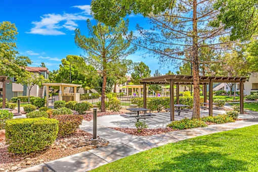 A sunny day at the park with a picnic table and benches.
