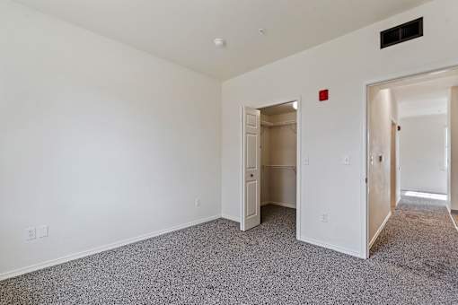 A room with a carpeted floor and a white wall.