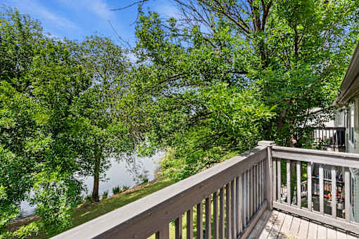 A balcony with a view of a lake and trees.
