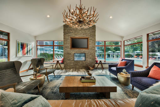 Clubhouse lounge with stone fireplace and large windows at Canyon Creek Apartments, Wilsonville