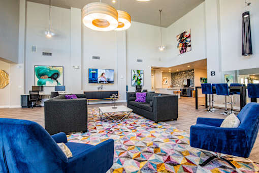 A living room with a blue chair and a colorful rug.