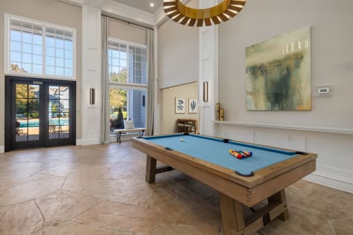 pool table in clubhouse with large windows