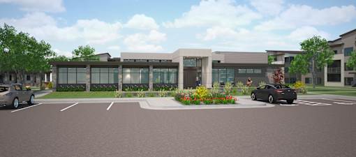 A modern building with a parking lot in front.
