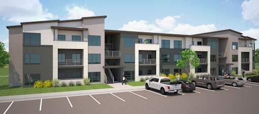 A modern apartment complex with a parking lot in front.