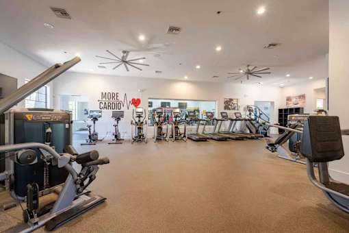 A gym with a variety of exercise equipment and a sign that says