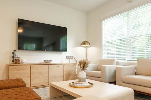 A living room with a flat screen TV mounted on the wall.
