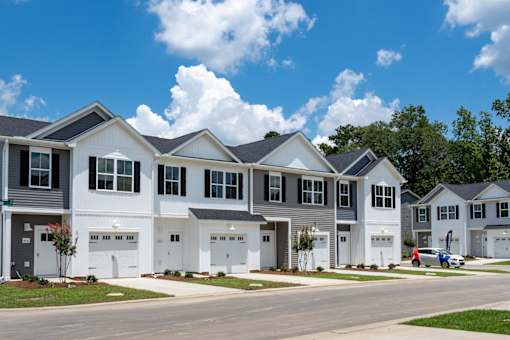 A row of houses with garages and driveways.