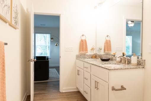 A bathroom with a sink, mirror, and towel rack.