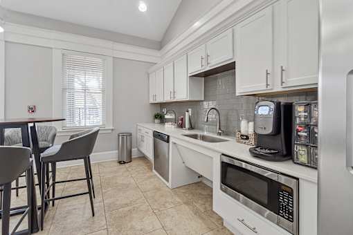 A kitchen with white cabinets and a tiled backsplash.