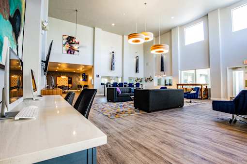 A modern living room with a white counter and a large painting on the wall.